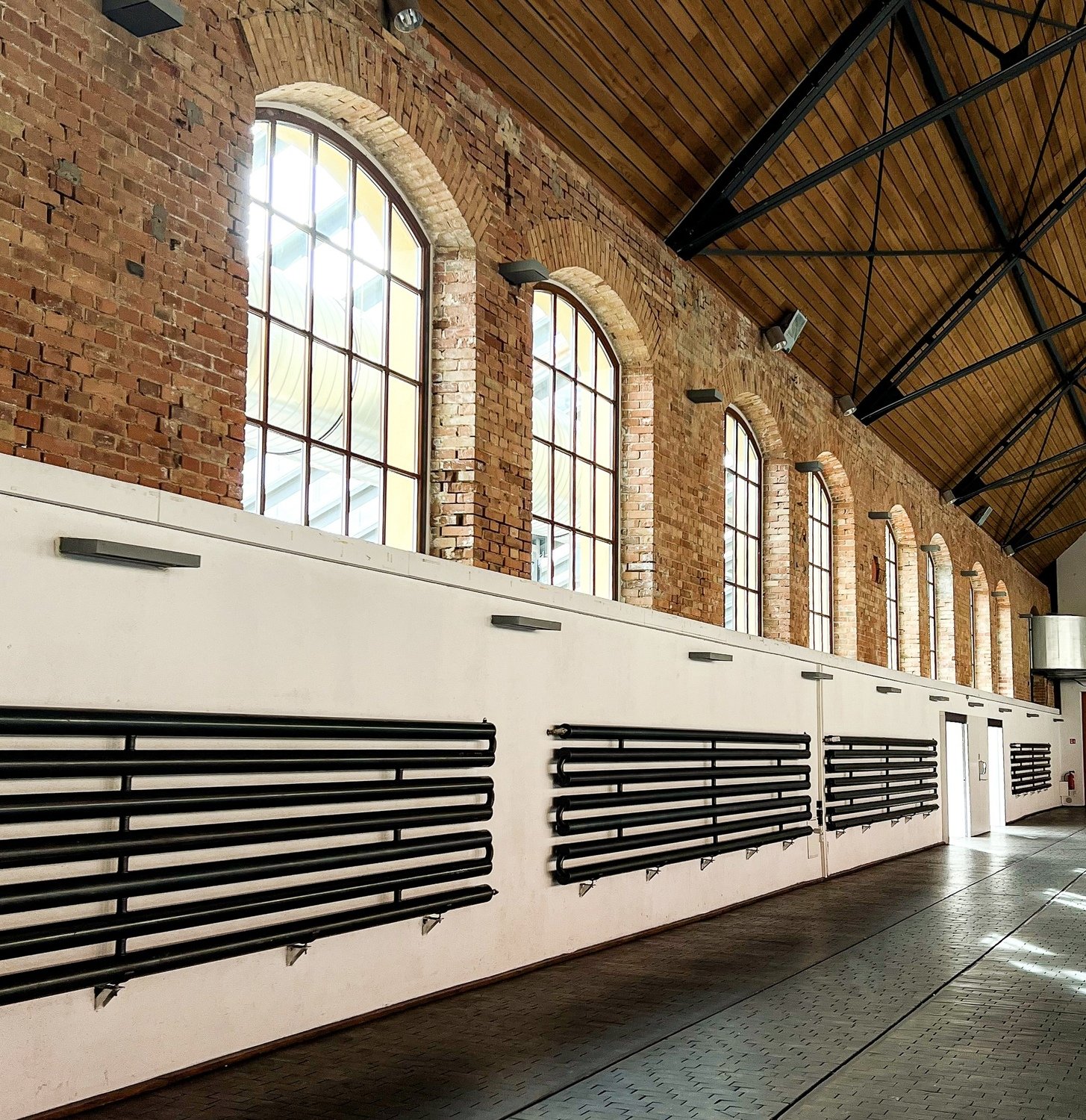 Innenansicht der Phoenixhalle im Römerkastell Stuttgart mit historischem Backsteinmauerwerk, hohen Rundbogenfenstern und moderner Industriearchitektur