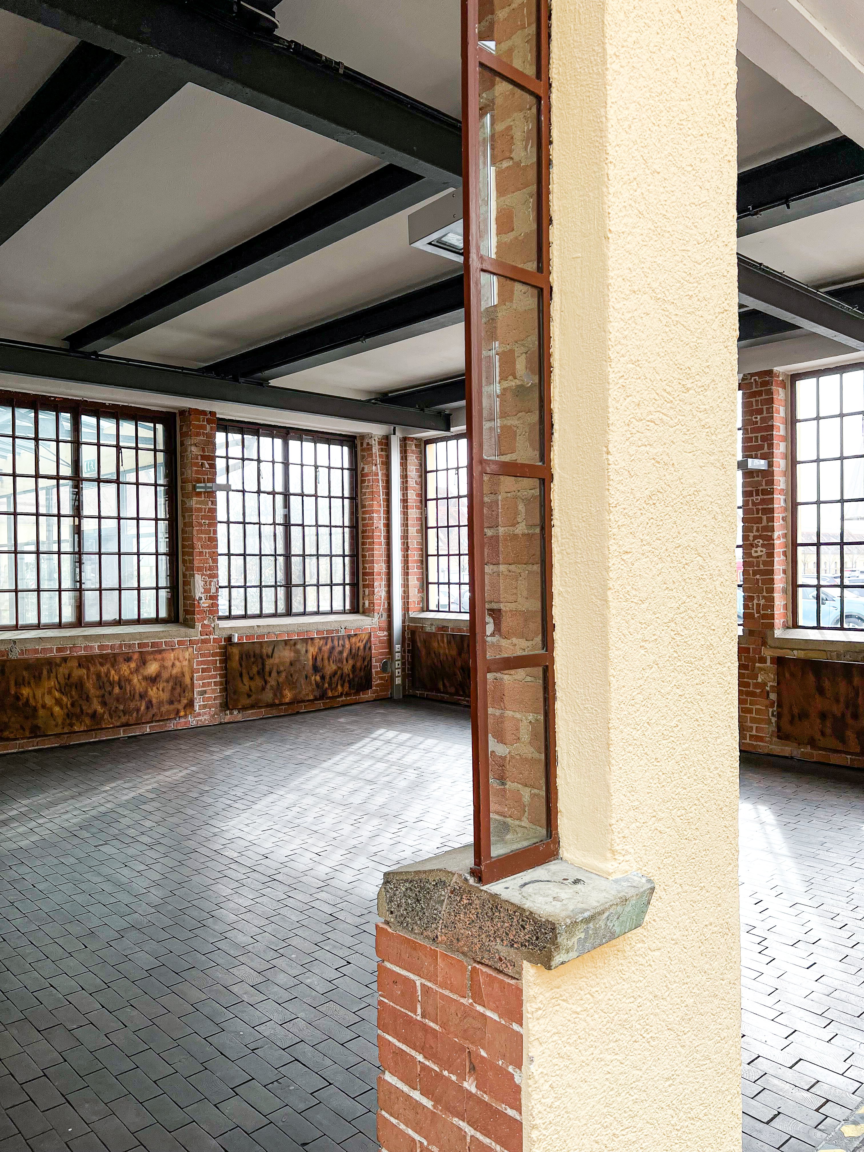 Innenansicht der Phoenixhalle im Römerkastell Stuttgart mit historischem Backsteinmauerwerk, hohen Rundbogenfenstern und moderner Industriearchitektur